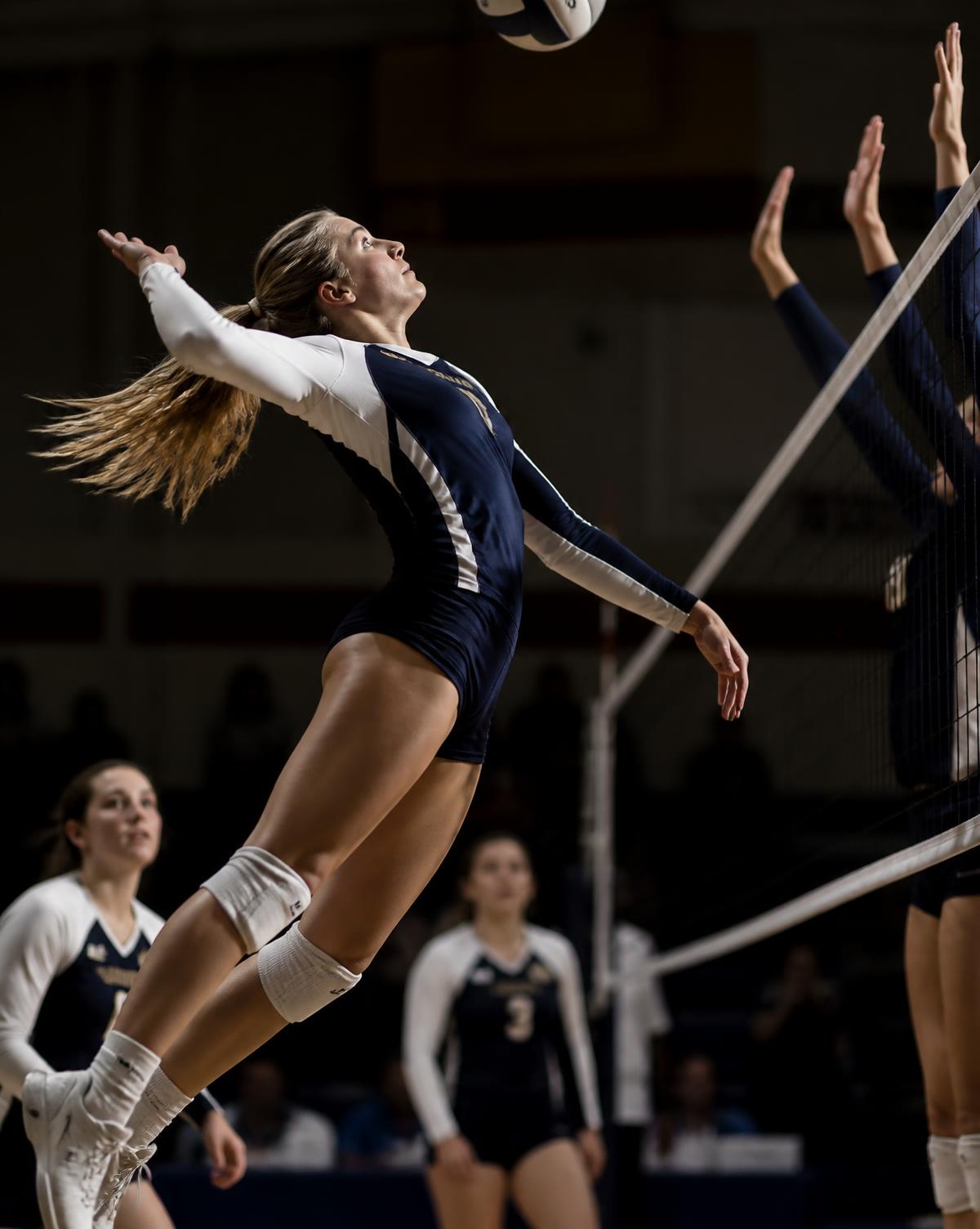 Volleyball player leaping for a spike at the net